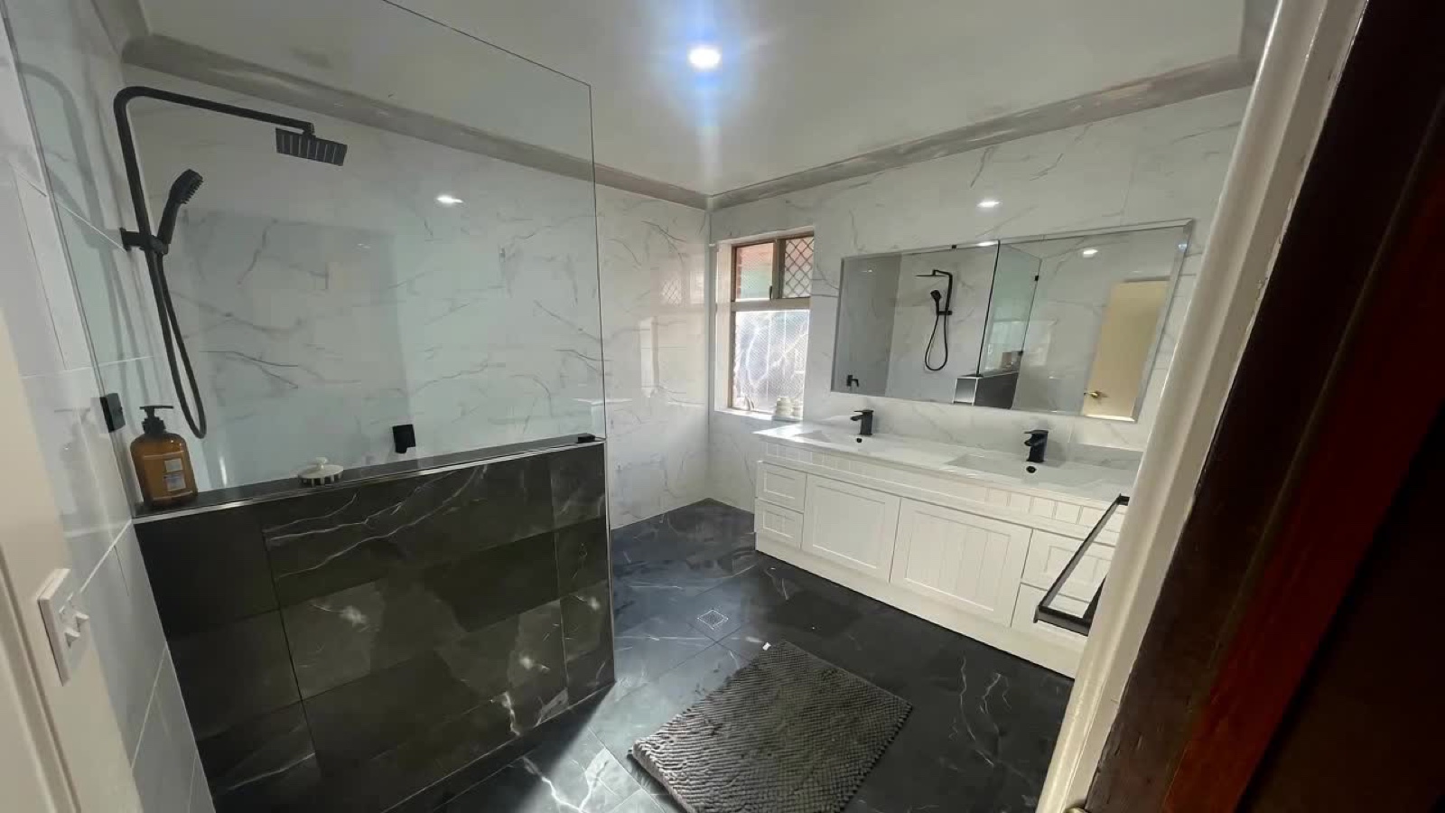 A finished bathroom fit-out by Reddy for Carpentry in Perth, with marble-look tiling and a custom vanity.